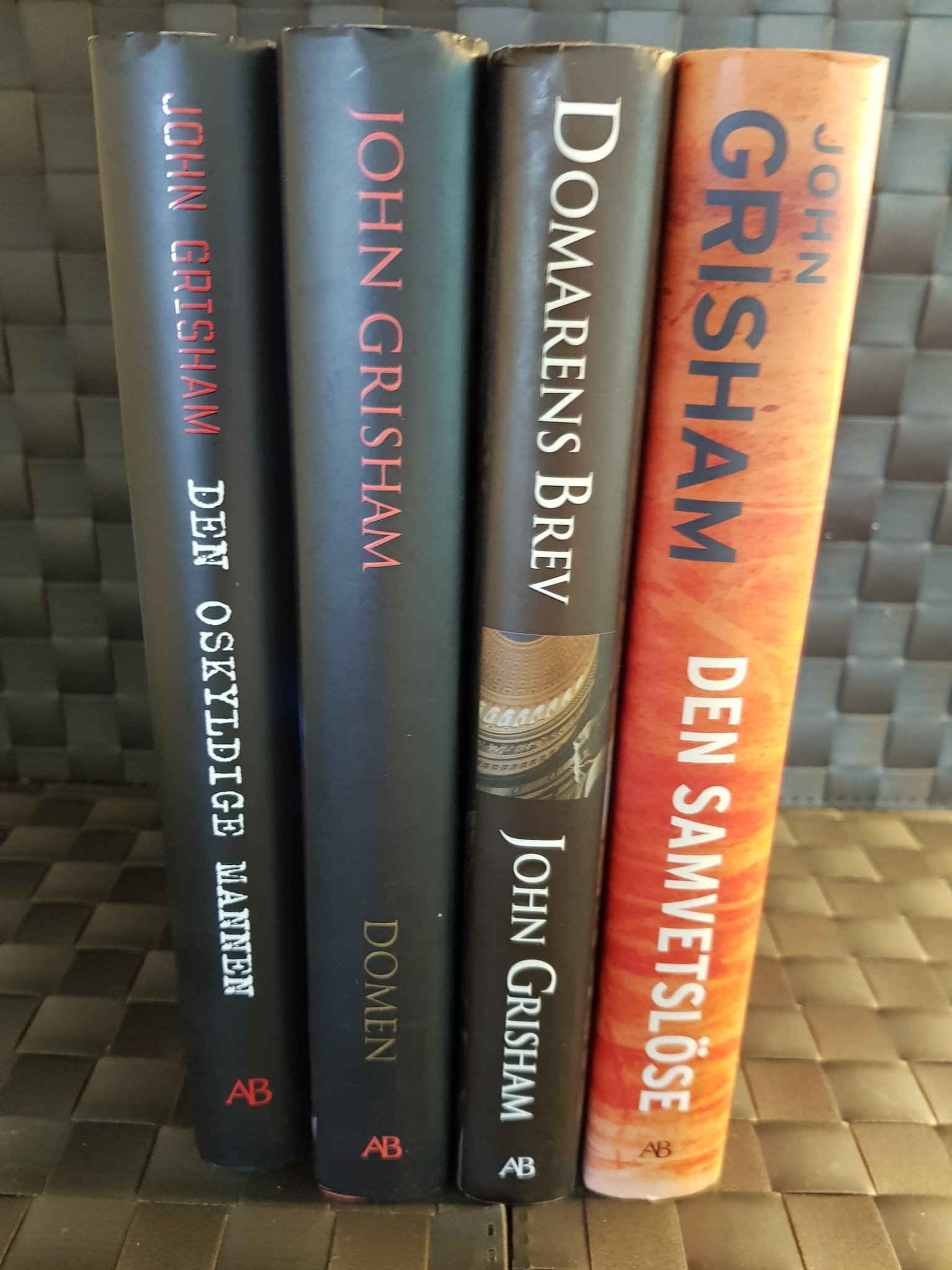 Fyra inbundna böcker av John Grisham.