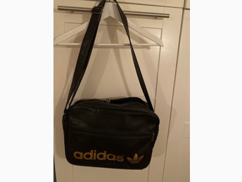 Adidas klassisk väska i svart med guldtext Adidas klassisk väska i svart med guldtext