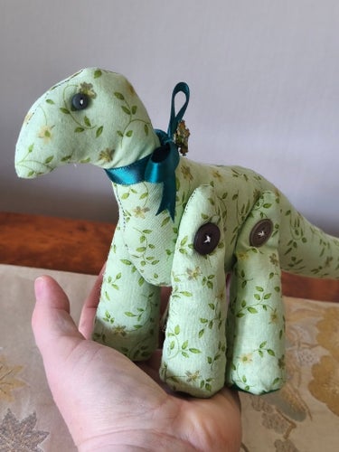 Söt blommig dinosaurie i tyg
