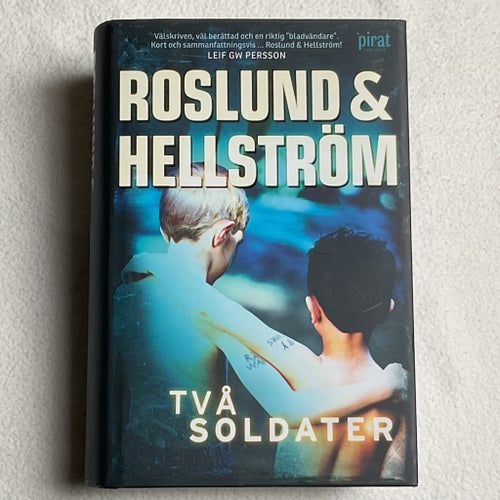 ROSLUND&HELLSTRÖM, TVÅ SOLDATER, INBUNDEN 1:A UPPLAGA 2012, SKYDDSOMSLAG