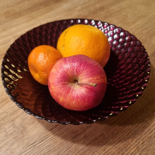 Fin liten fruktskål i djupare rött med gyllene inslag