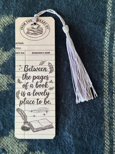 Bokmärke med texten "Between the pages of a book is a lovely place to be."
