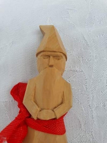 Träfigur med rött band. Snidad liten tomte. Hårt trä