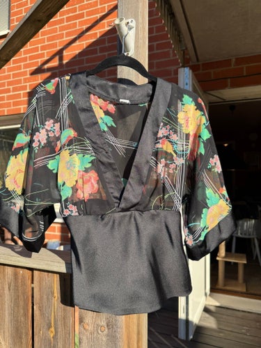 Svart blus med vacker blommig övre del, storlek 34