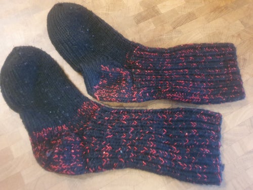 Svarta, röda strumpor med glittergarn. Handstickade från Jämtland.