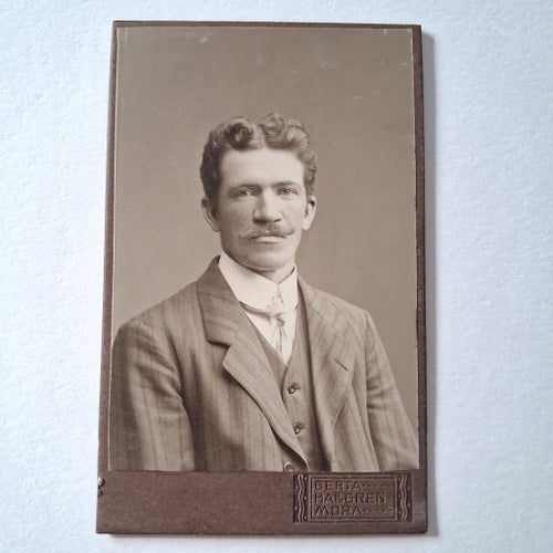 Porträttfotografi av man med härligt hår och mysig mustasch