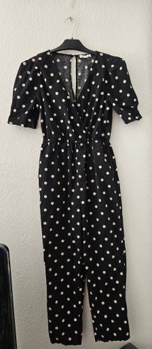 Svart jumpsuit från H&M med vita prickar I storlek 36-38.