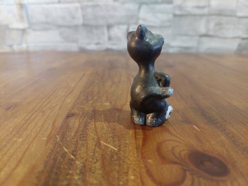 Charmig miniatyr Svart kattfigur med mus