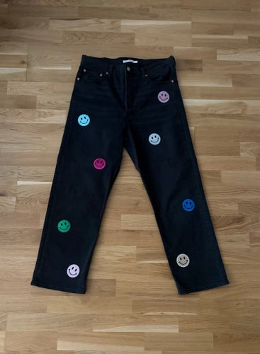 Levi's svarta jeans, storlek 32 med glittriga smiley - patches