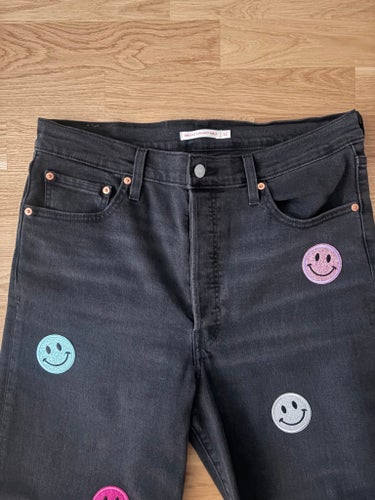 Levi's svarta jeans, storlek 32 med glittriga smiley - patches