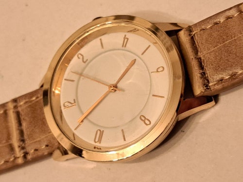 Guldpläterad klocka med ljust läderarmband. Nytt batteri. Fungerar bra.