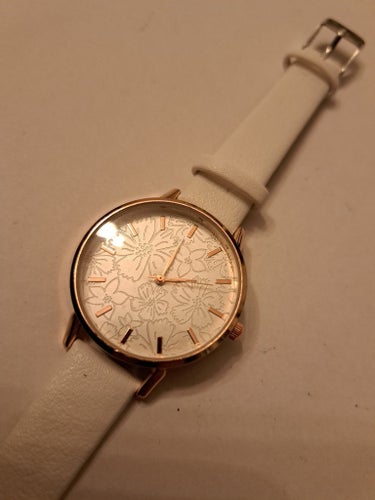 Elegant damklocka med blommönster och vitt läderarmband