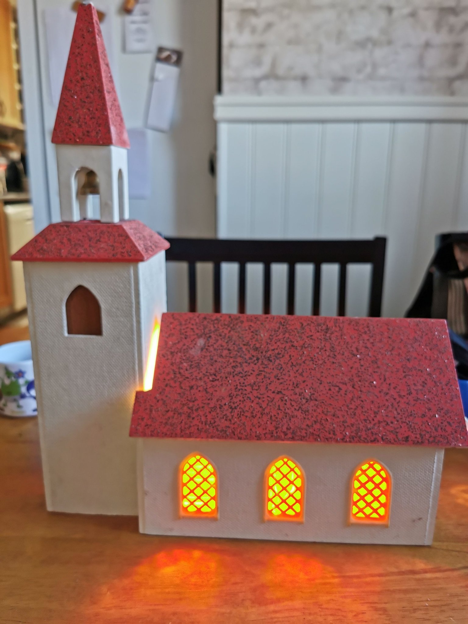 Defekt äldre julkyrka vit med rött tak, belysni ...