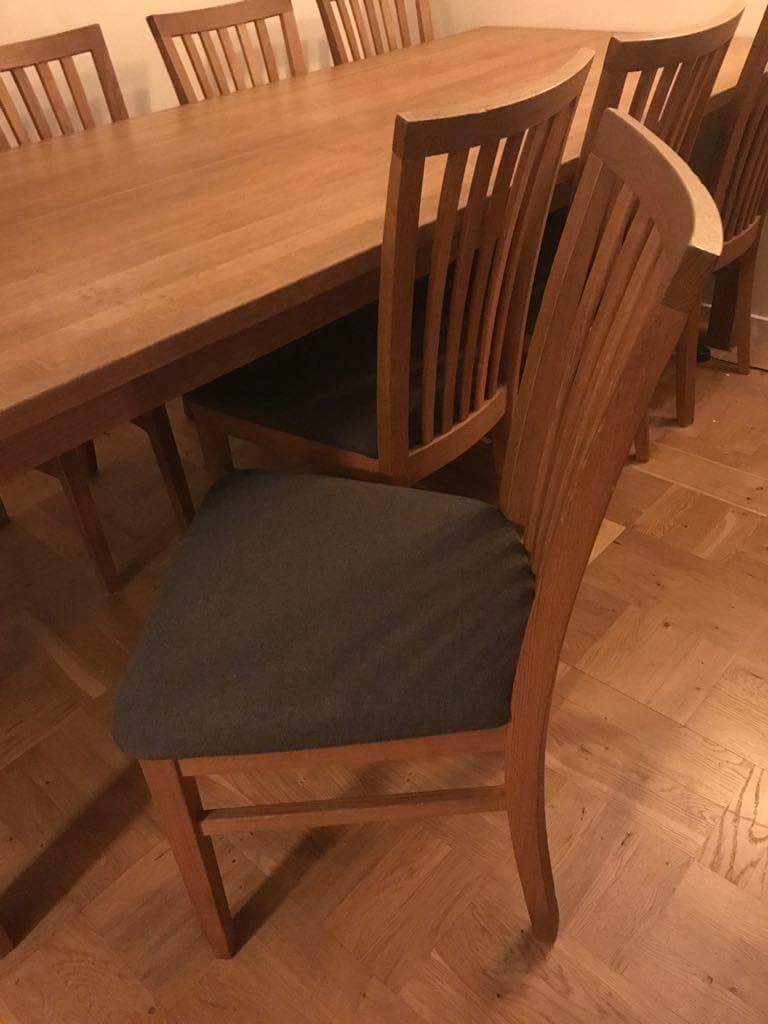 Stort matbord i massiv ek samt 12 stolar i ek med grå tygsits på