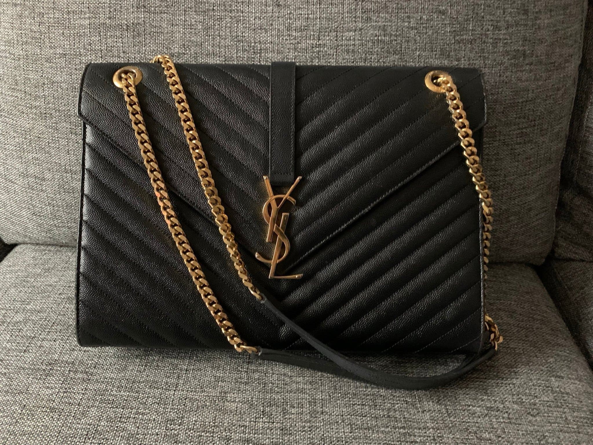 Yves Saint Laurent konvoluttveske i lær med embossing i svart og gull