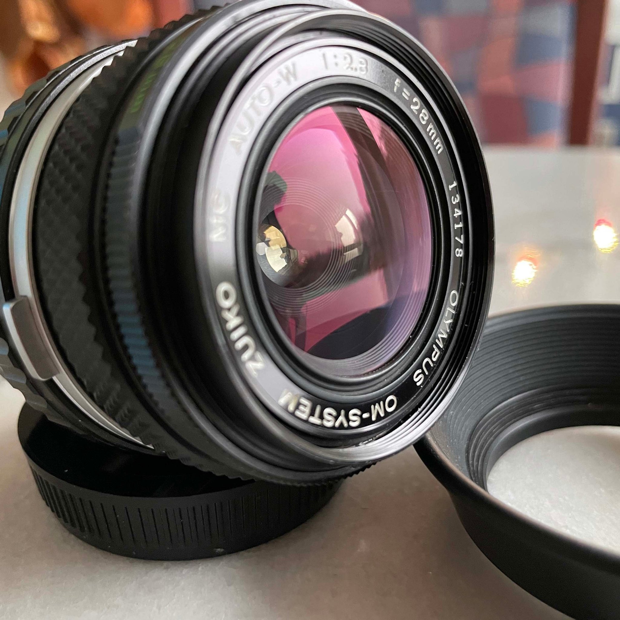 OLYMPUS OM 28mm f2.8 MC + OLYMPUS Lens Hood 28f.. Köp på Tradera