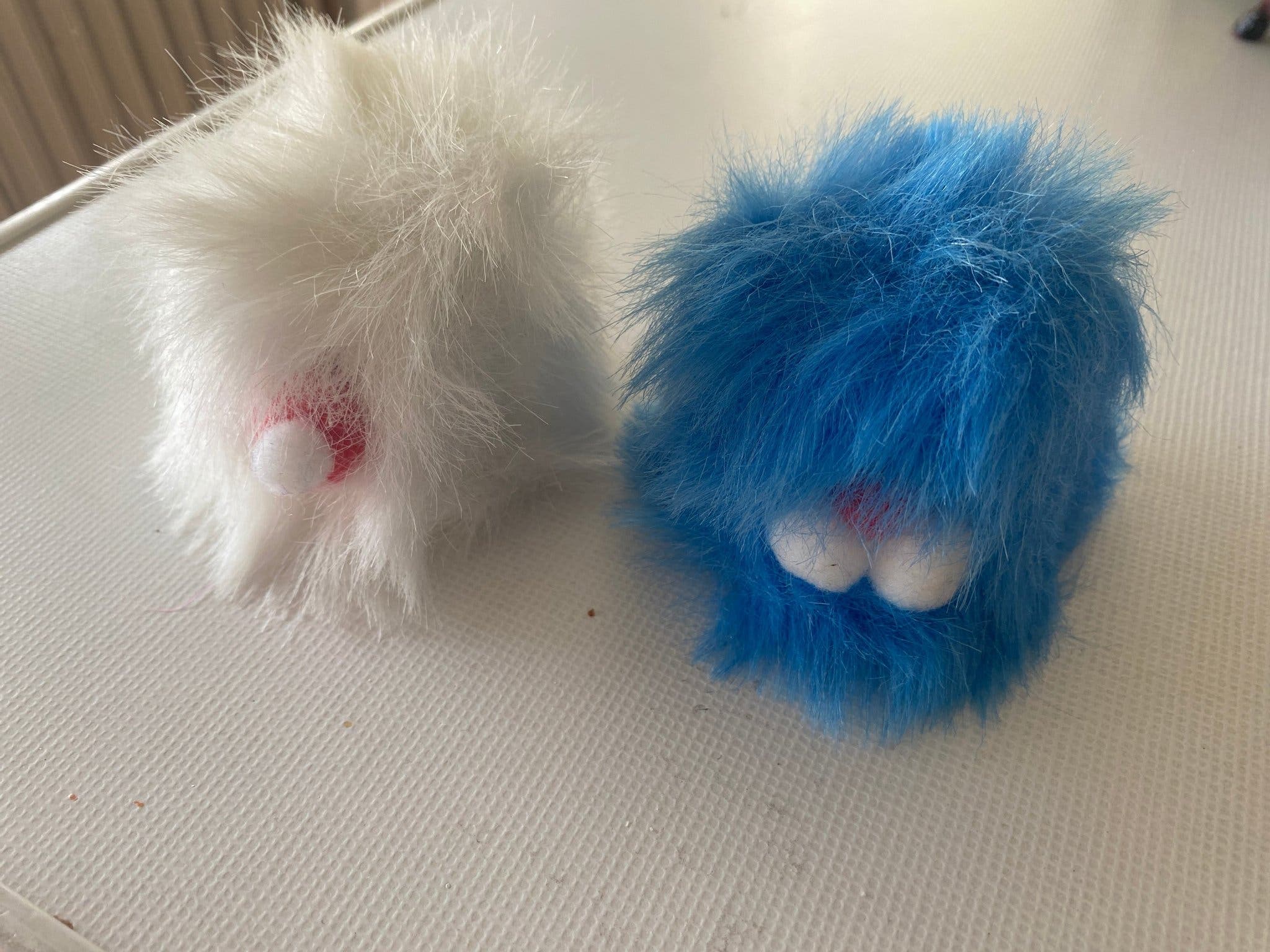 Two fluffy 'troll' figures in white and blue