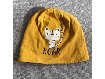 Gul tunn mössa med tiger och text roar stl 74-80