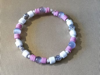 ett egenhändigt gjort armband i rosa, vit och silver.