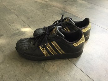Adidas svarta sneakers med gulddetaljer, storlek 35 Adidas svarta sneakers med gulddetaljer, storlek 35