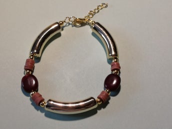 ett egenhändigt gjort armband. I färgerna guld, brun och ljus