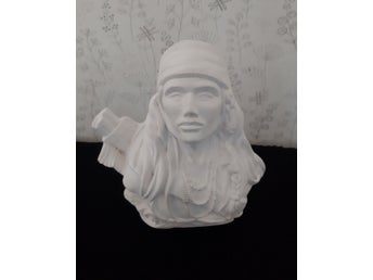 Indianhuvud. Vit keramik. Kallmålning. Det är ca 16 ×16 cm.
