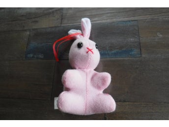 Liten rosa kanin med hänge