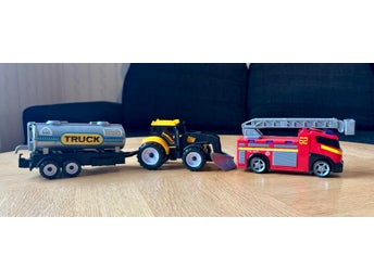 Fyra leksaksfordon: tanksläp, traktorer och brandbil