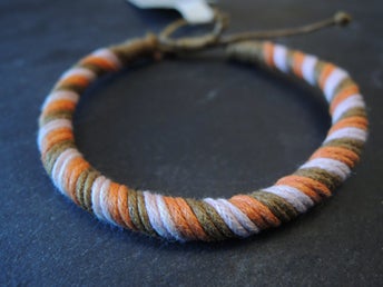Handknutet armband i rosa/orange/brun cord