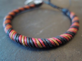 Handknutet armband i röd/svart cord.