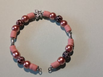ett egenhändigt gjort armband i ljus tegel, brun med små blommor samt