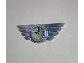 Äldre klocka i metall väggklocka formad som Flygvinge 34,5 cm