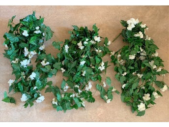 Långa växrankor med vita blommor. Konstgjorda växter.
