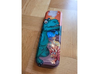 Pennskrin i metall med dinosauriemotiv
