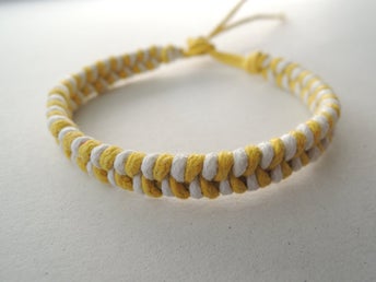 Handknutet armband i gul/vit cord