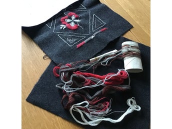 Fingerfärda ”sitt fint” sittdyna i vadmal med yllegarn, påbörjat broderi.