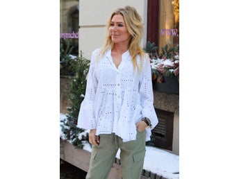 Vit blus med broderimönster och volang