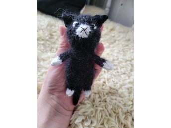 Liten stickad svartvit katt
