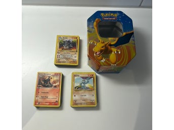 Pokémon-kort från 90-talet och plåtlåda med pokémon-tema.