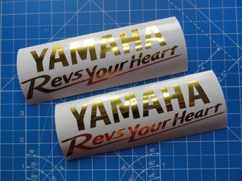 [ DEKAL ] YAMAHA Revs Your Heart. Två st. 15 x 4.6 cm. Guld Krom
