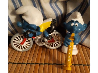 Två Smurf-figurer: Smurf på cykel och Smurf med flöjt