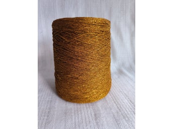Glittrande garn på kon, ca.600g. utan kon, 80% viskos, 20% lurex, mörkguld, lace