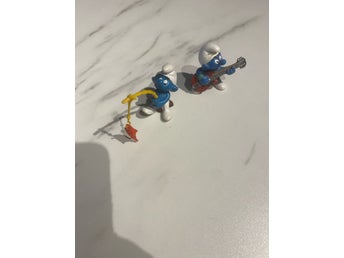 Två Smurf-figurer: fiskare och gitarrist