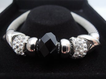 Läckert flätat armband med svart pärla i gåvoask