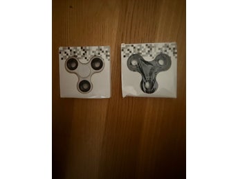 Två stycken fidget spinners, vit och