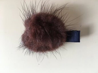 1 liten hårklämma med brun pälsboll