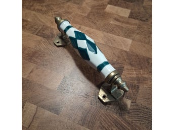 Handtag i keramik och mässing