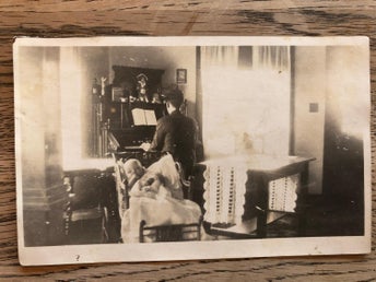 Äkta fotografivykort med piano spelare och bäbis