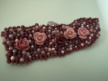 Ett handgjort sytt armband, med brun till beige blommor