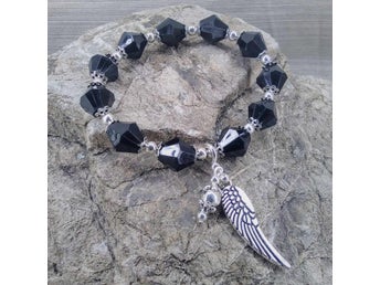 Armband med 11 svarta pärlor. Änglavinge, 19 cm.